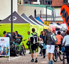 Row of 4x4 m black and lime tents with Ergon logo side walls at the Brixen Bike Festival