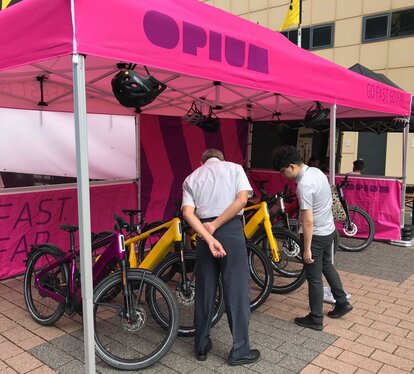 Pink 6x4 m Ecotent® folding tent with OPIUM branding and e-bike display.