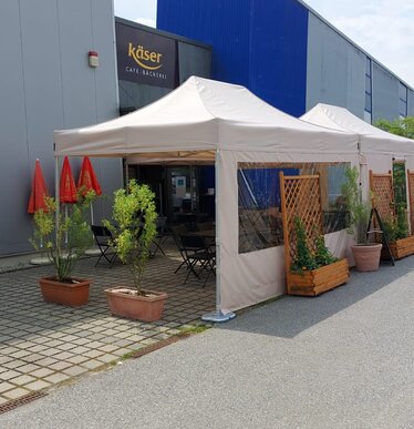 2 folding gazebo measuring 4.5x3 m stand in front of the Käser bakery in Vilshofen. They serve as canopies for the guests.